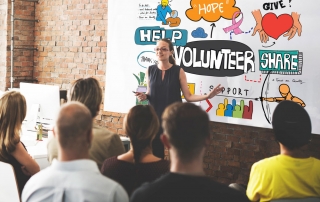 Image of person talking about volunteering to a group